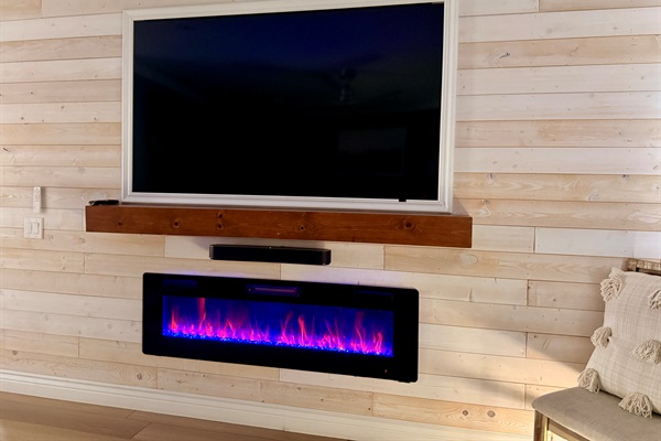 Primary bedroom entertainment center includes a 75" smart tv and electric fireplace.