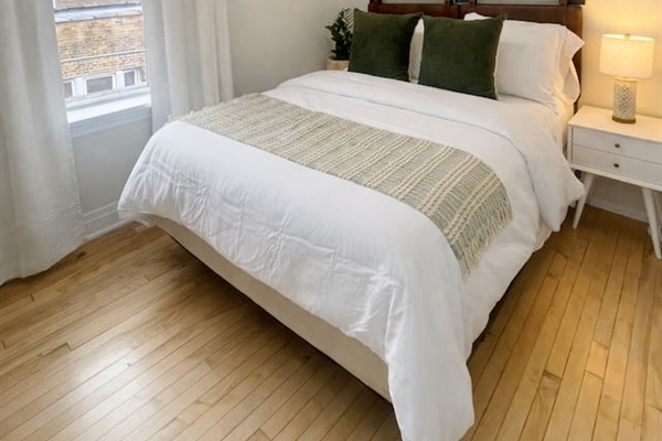 Comfortable bedroom with large windows and cozy bedding.