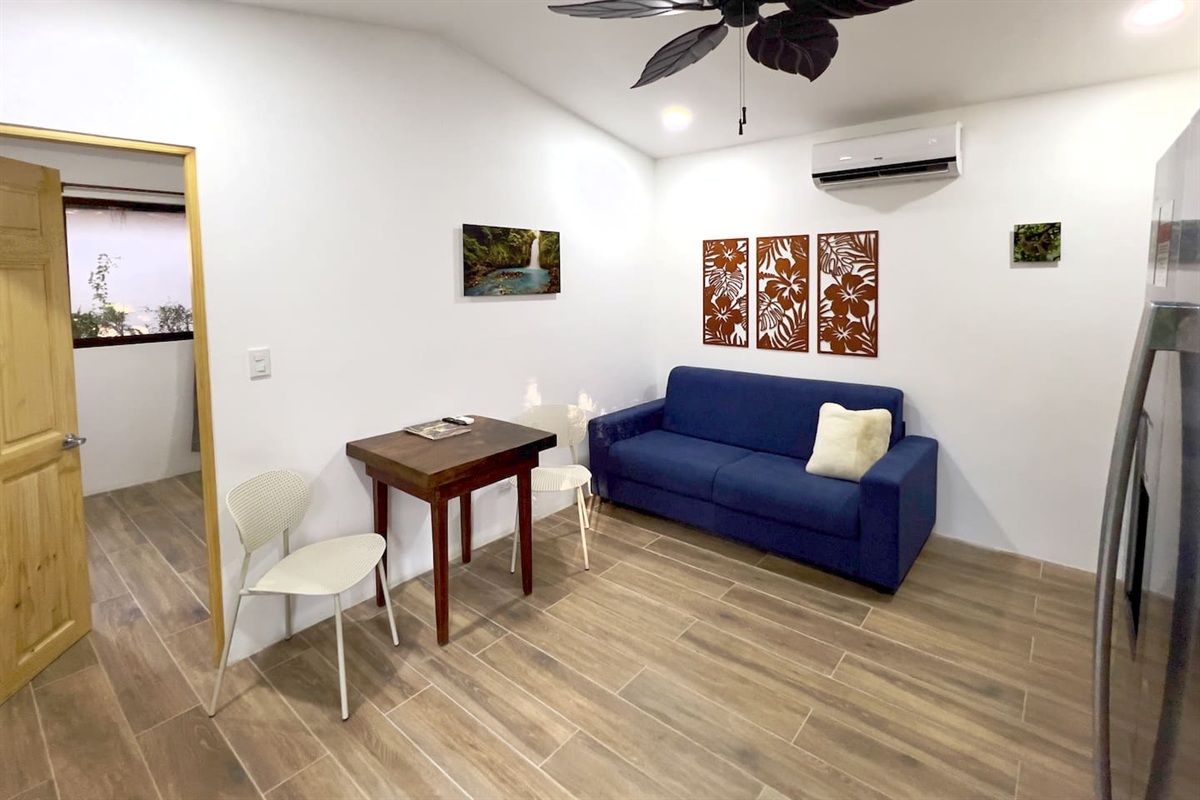 Casa Cocos living room with full-size sleeper sofa.  Two person dining area is next to the bedroom door on the right.