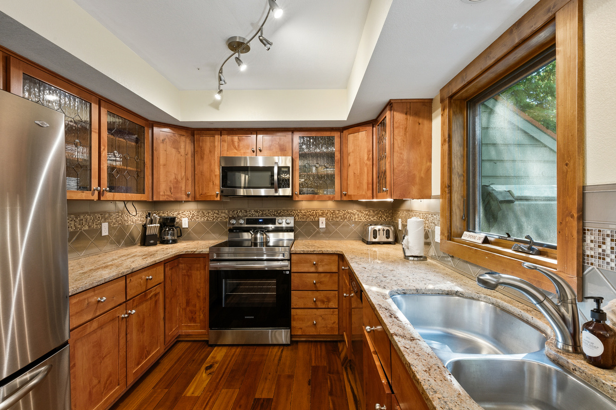 Well-stocked kitchen with view of hot tub and woods from kitchen sink window. 