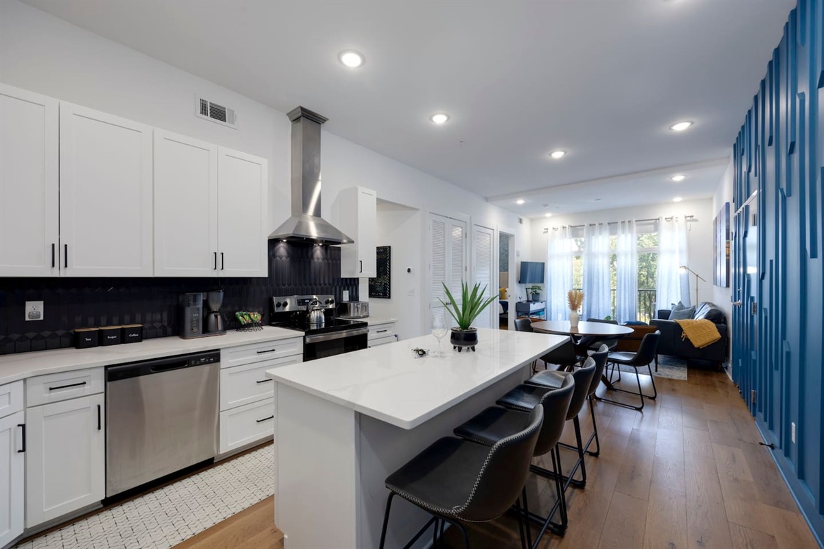 Island has 4 comfortable chairs for guests to sit and visit while cooking in the kitchen.