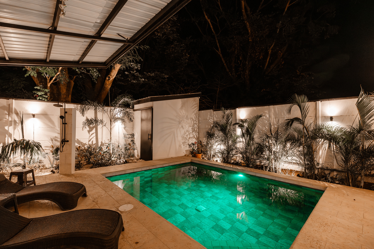 Same pool, teal-lit. Outdoor shower a few steps away