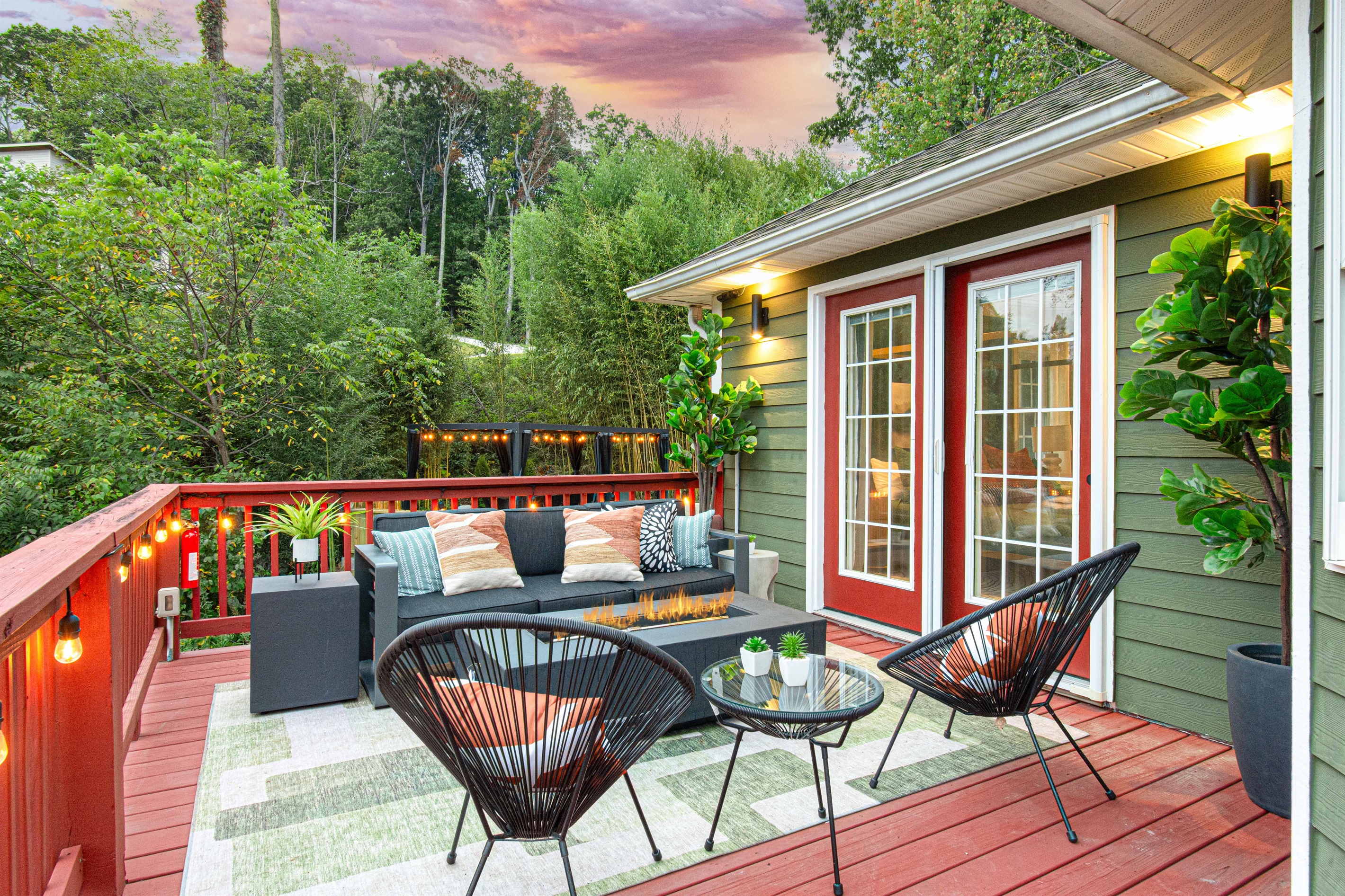 Relax in style on this serene deck, directly outside the upper level master, complete with cozy seating, ambient lighting, and lush views—your perfect spot for a peaceful evening or lively conversation.