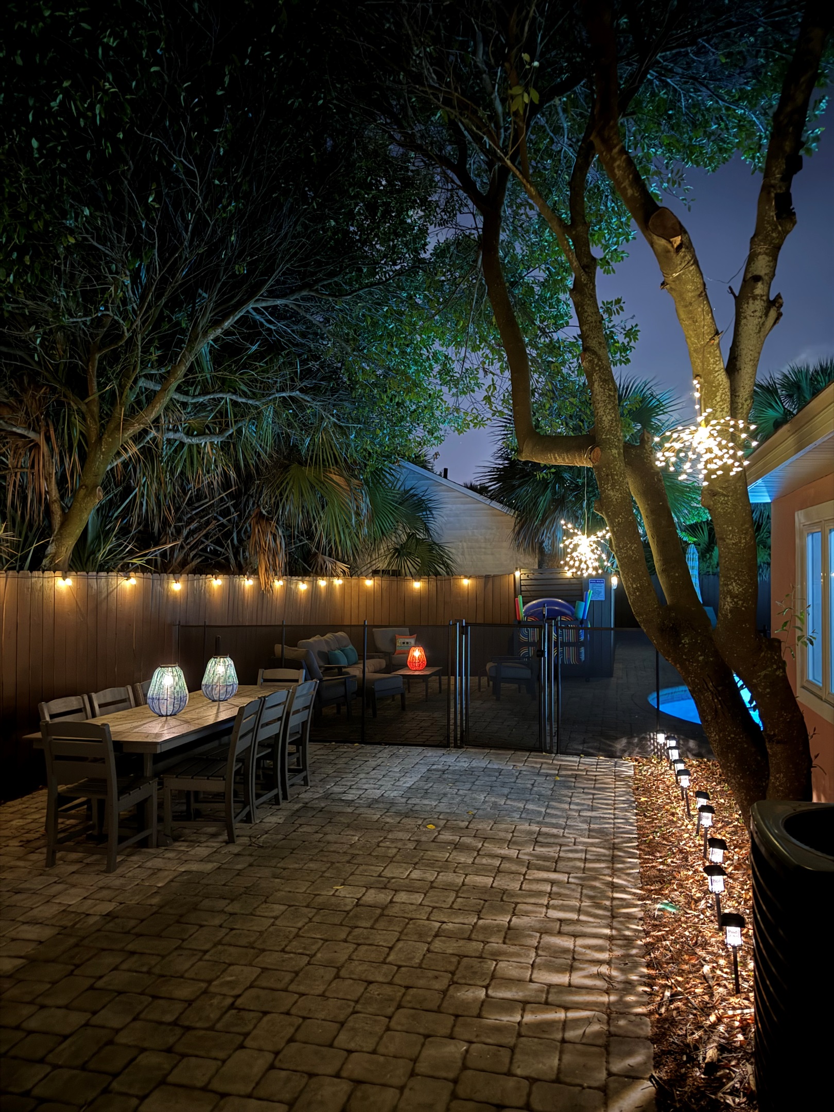 String lights above, illuminated pool below. Nighttime on the Salt & Sway patio has its own atmosphere, and the dining set stays ready for whoever wants to linger.