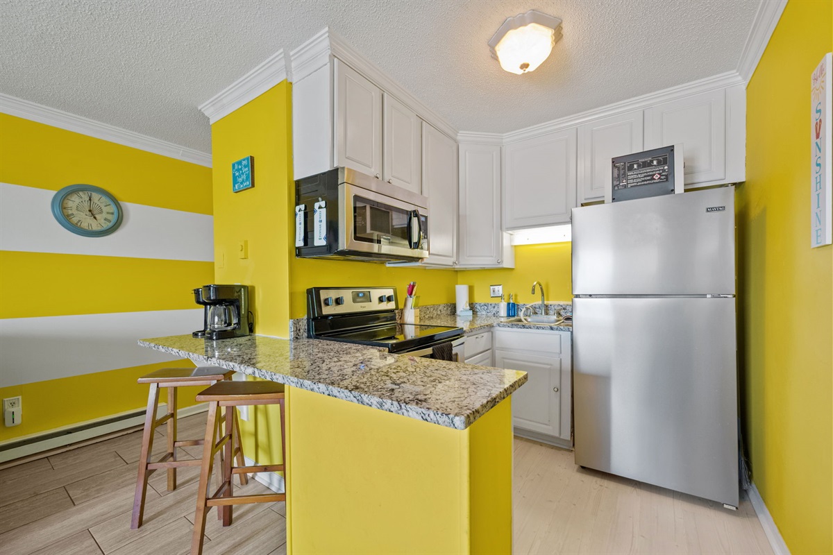 Bright kitchen with stainless appliances and granite countertops for simple coastal meals