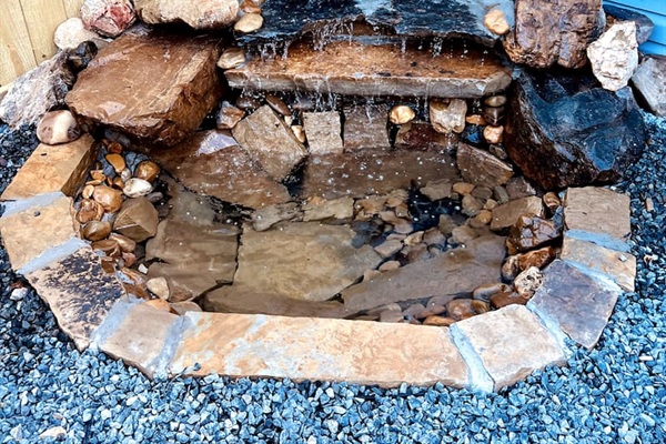 Outdoor Oasis: Enjoy tranquil moments by the charming waterfall feature in the private yard!