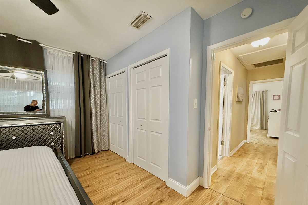 This bedroom shines with sophistication—boasting polished floors, sleek décor, and a cozy king bed.