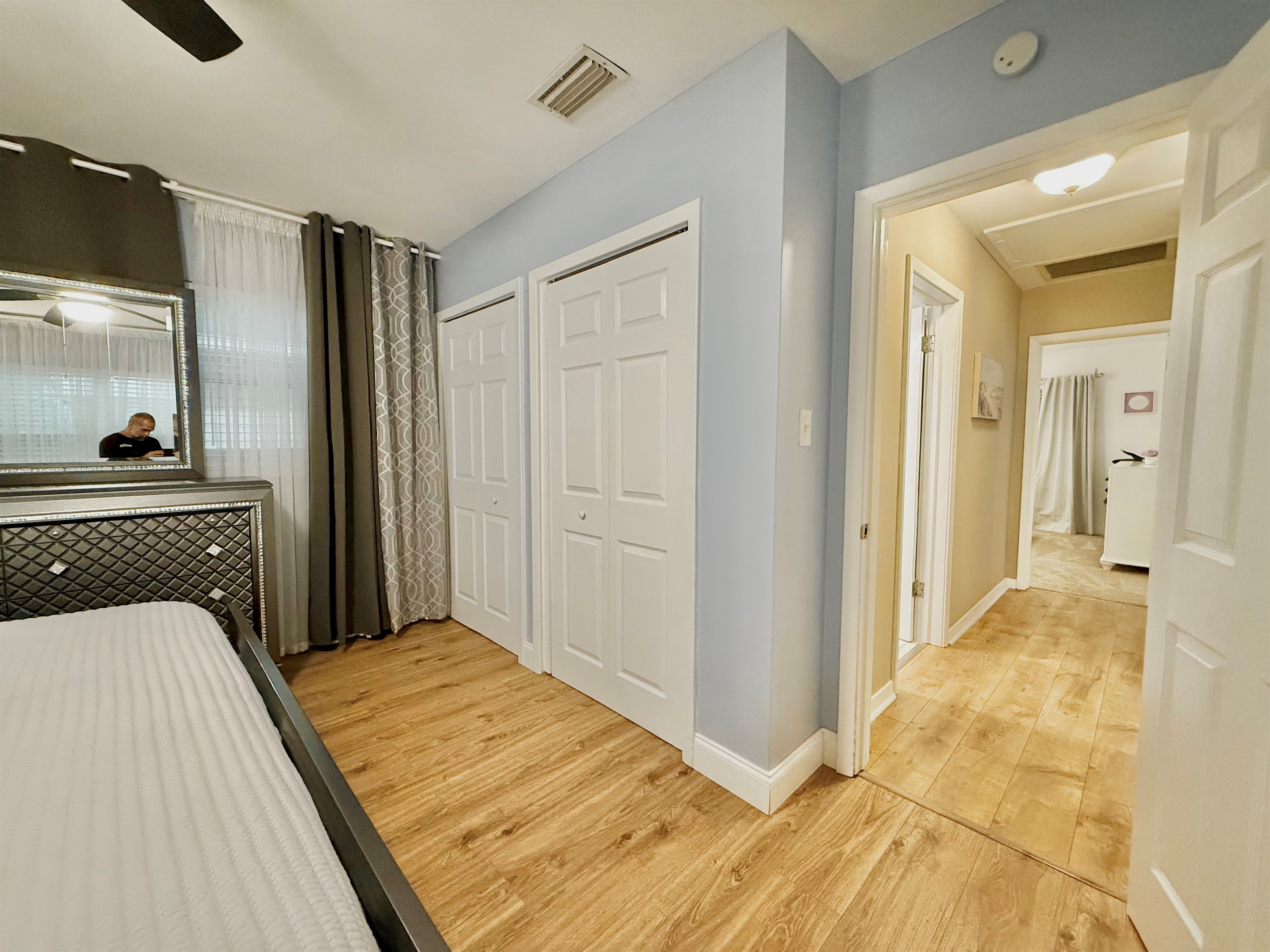 This bedroom shines with sophistication—boasting polished floors, sleek décor, and a cozy king bed.