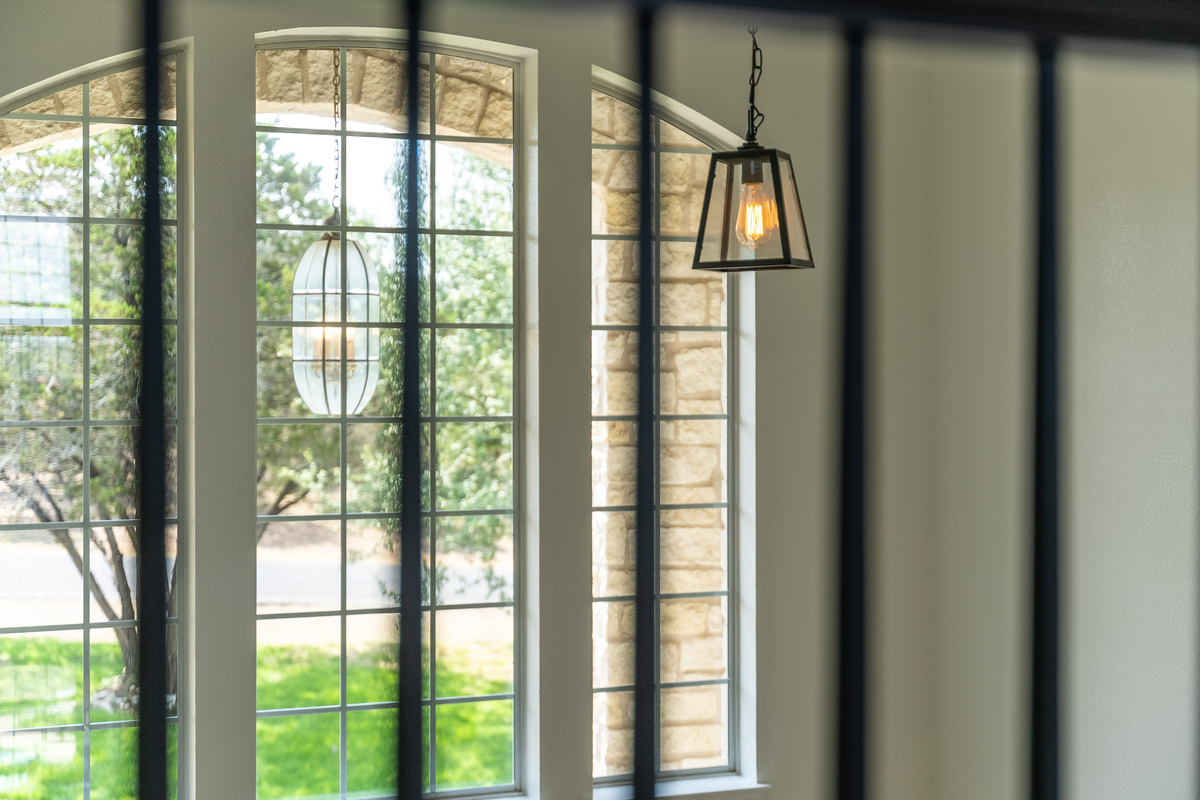 Arched windows and iron accents flood this entryway with natural charm.