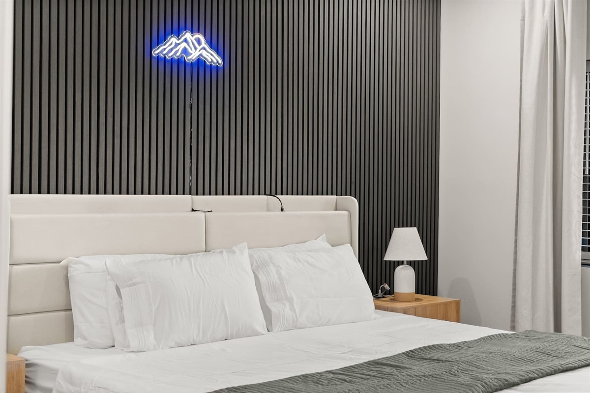 Two twin beds placed close together, easily separated if needed, with convenient built-in phone chargers—practical and comfortable for any guest.