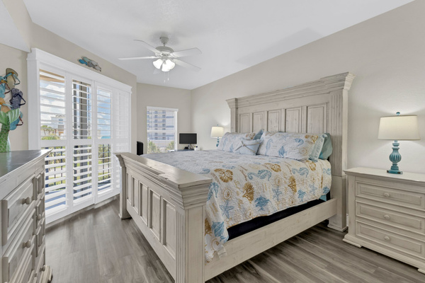 King bed with night stands, dresser, corner desk with monitor.