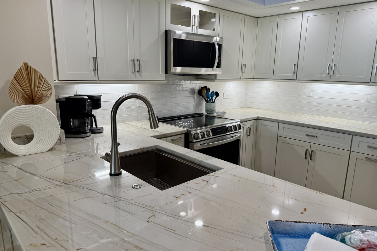 Remodeled Kitchen with Expanded Solid Surface Countertops & White Shaker Cabinets.