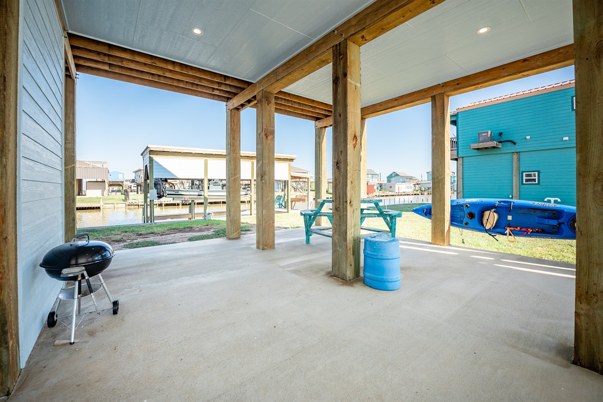kayaks, seating and charcoal grill for guest use under the house