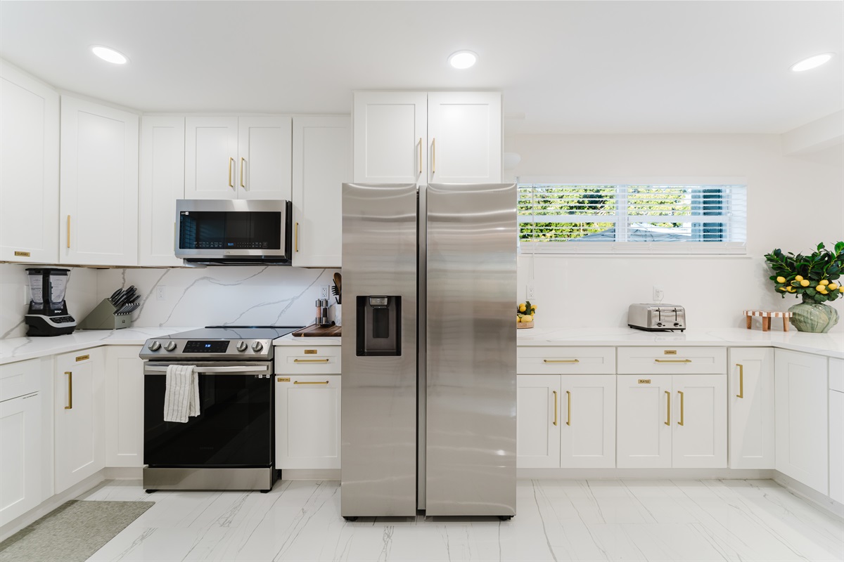 Bright, open-concept kitchen with quartz countertops, stainless steel appliances, and abundant prep space—perfect for family meals and entertaining. Fully stocked with a premium coffee setup, modern finishes, and seamless flow to dining and outdoor areas.