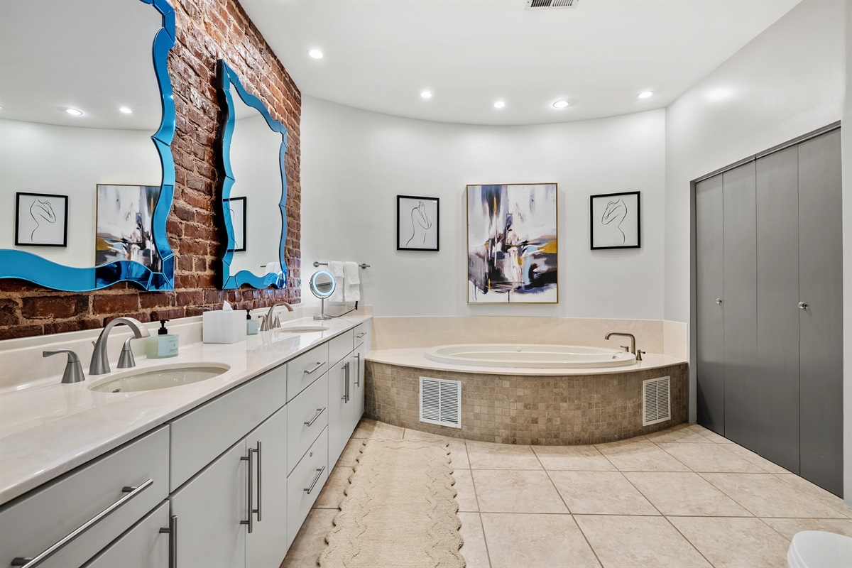 Modern ensuite featuring a spacious walk-in shower and relaxing jetted tub.
