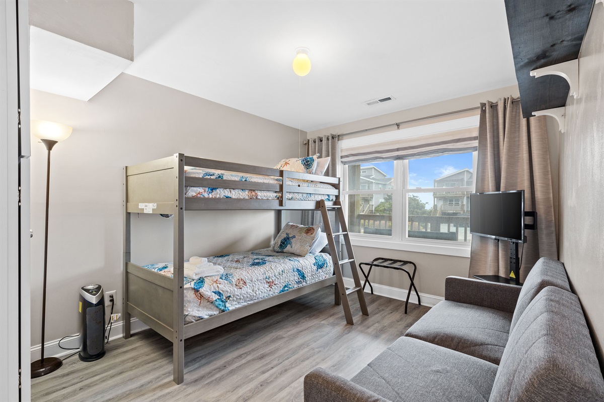 Kid-friendly bunk room with twin beds and space to relax or watch TV