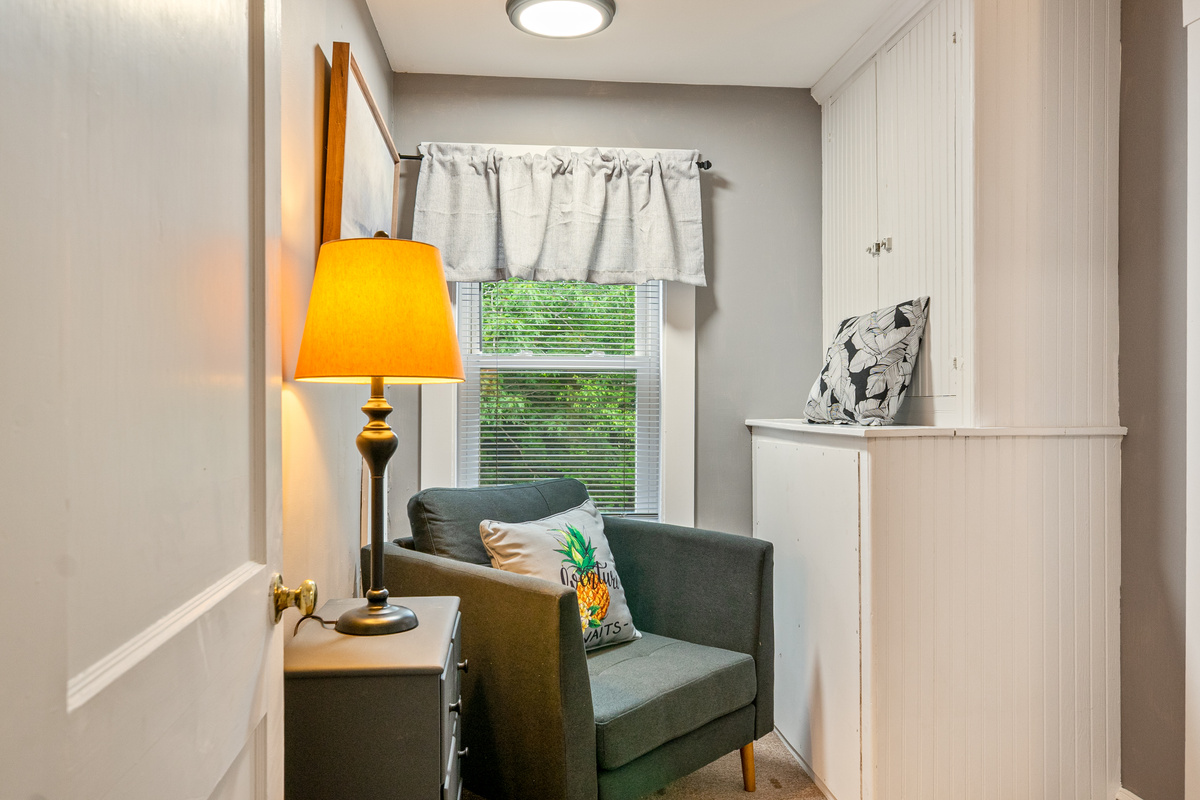 Step into The Pebble Nook, a flexible space positioned right off the landing. Featuring a cozy armchair, a reading lamp, and an adjacent chest of drawers, this private alcove offers a quiet, sunlit corner to relax and unwind during your stay.
