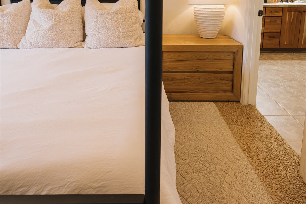 A serene primary suite designed for rest and retreat. Crisp white linens, plush textured pillows, and a statement four-poster bed create a cozy yet refined mountain feel. The private ensuite bathroom is just steps away, offering seamless comfort and conven