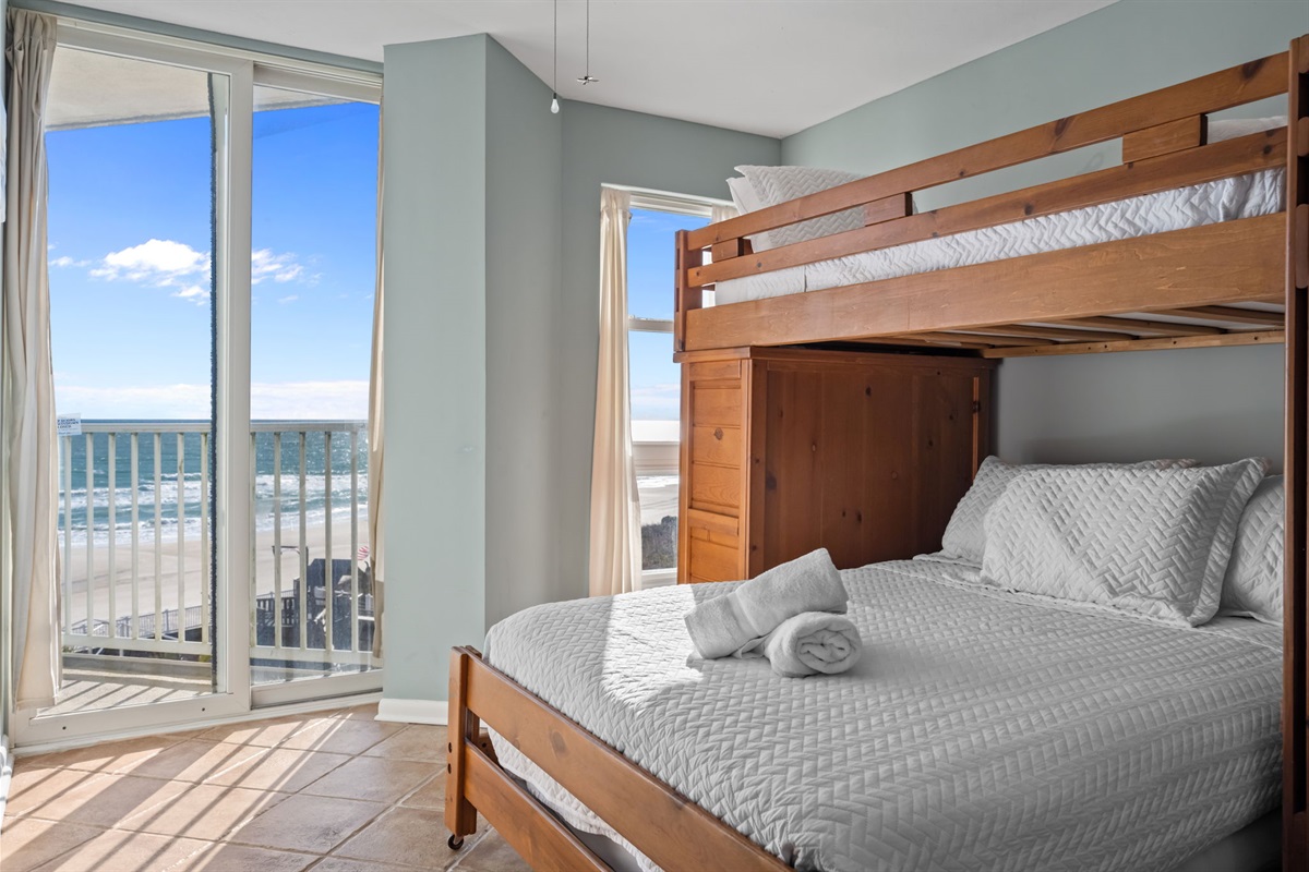Lower Full-size bed with cozy linens and easy access to balcony views of the ocean