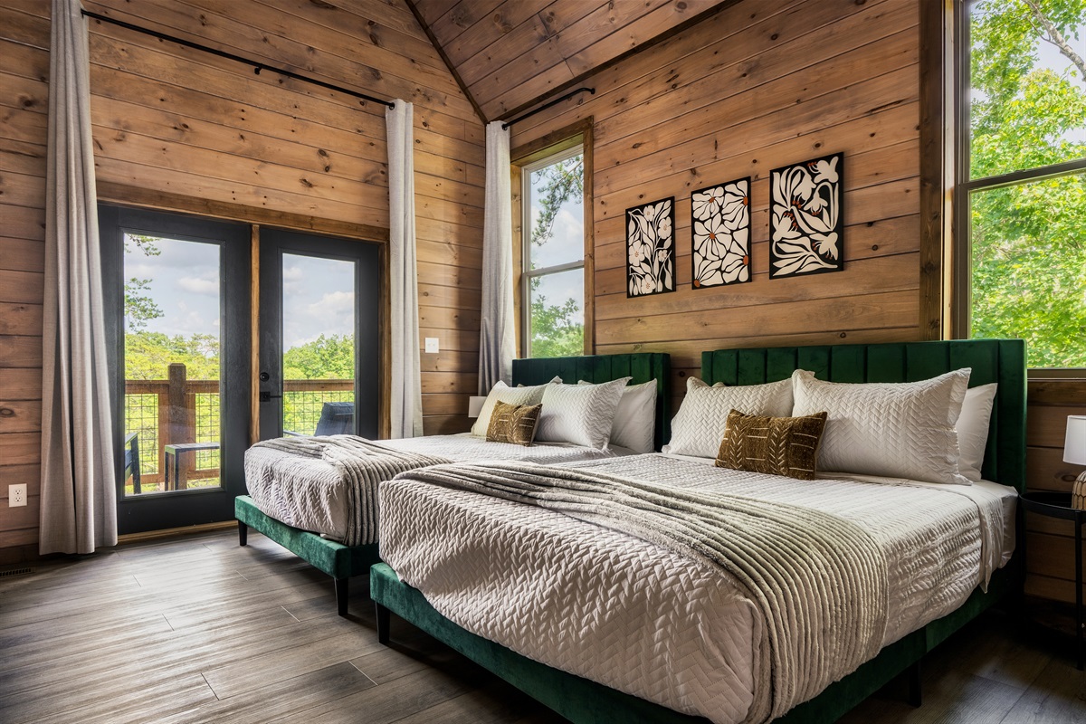 Bedroom with two queen beds, modern art, and plush linens