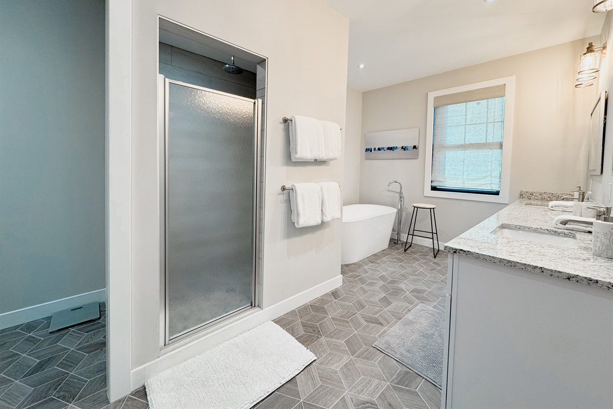 Spacious primary bathroom with tub and walk in shower.