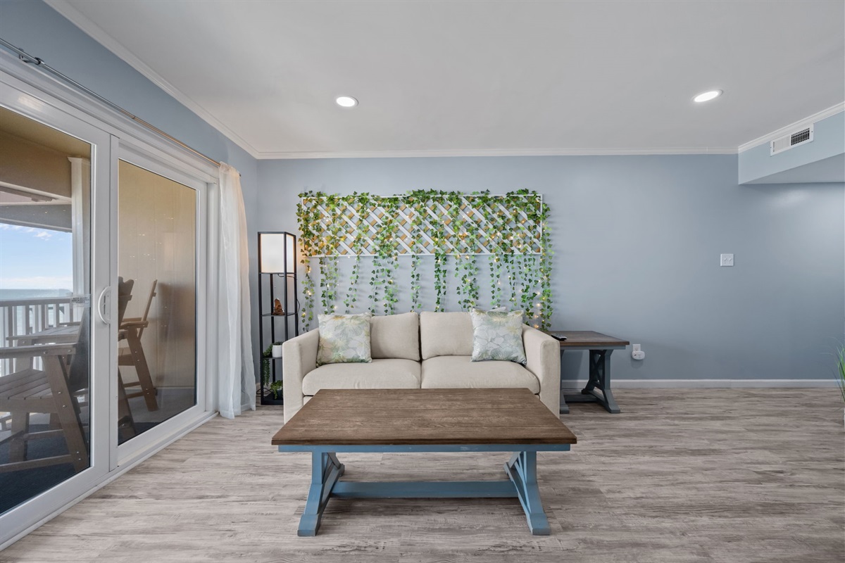 Unwind on the sofa with soft lighting and a calming ocean backdrop