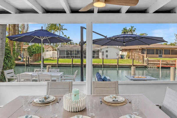 Relax on the screened waterfront patio with comfortable seating, dining space and a 65” TV.
