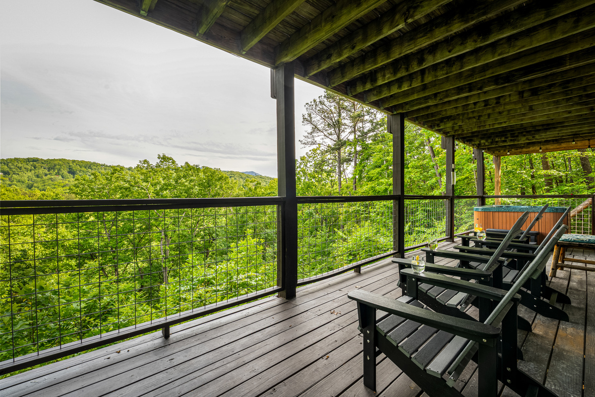 Lower level deck, with Adirondack chairs and hot tub. Accessible via interior and exterior stairs.
