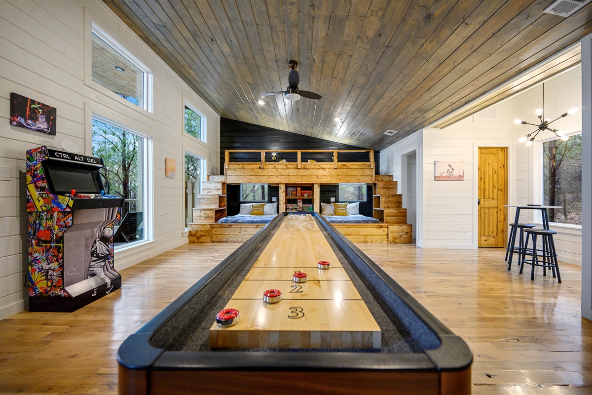 A lively game area featuring over 100 arcade games and a shuffleboard table — perfect for endless entertainment, friendly competition, and group fun indoors. 🎮🏓✨