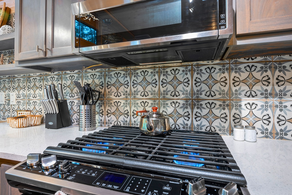 The cooktop and detailed backsplash add a bit of personality while still keeping the space clean and practical.