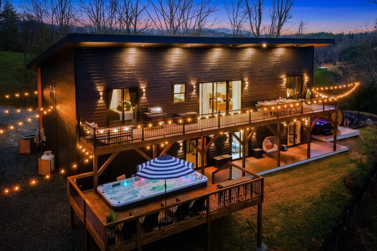 {Welcome} Nighttime at Summit House — soak in the swim spa on the elevated deck beneath glowing string lights, sharing stories over a glass of wine with mountain views all around. The perfect way to unwind and end the night.