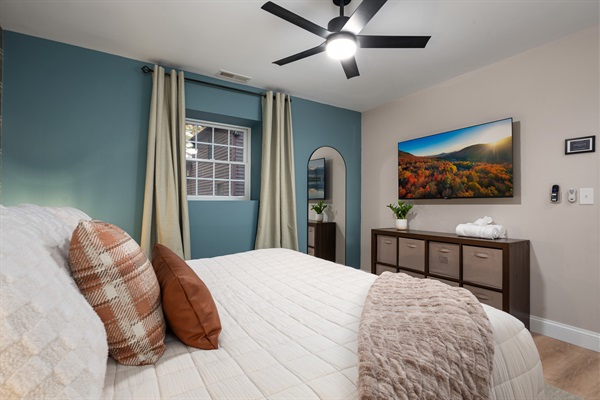 This inviting bedroom is designed for both comfort and convenience, featuring a large smart TV, storage for everyone’s essentials, and a warm, neutral palette. Ideal for parents who want to unwind with a movie after the kids are asleep down the hall.