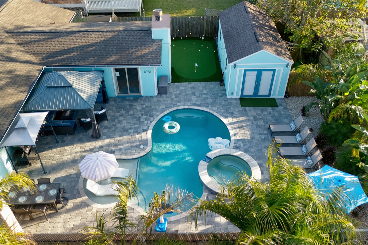 Heated pool surrounded by lush tropical landscaping