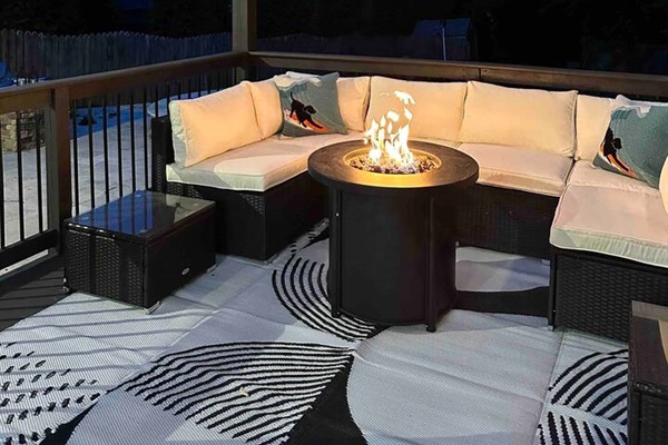 Stunning outdoor porch, complete with a cozy fire pit and a beautiful wood ceiling adorned with enchanting fairy lights.