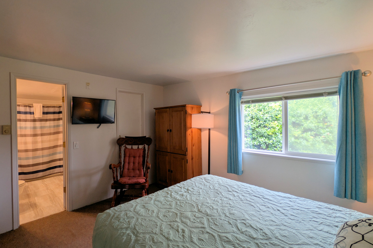 queen bedroom with TV, wardrobe & rocking chair.