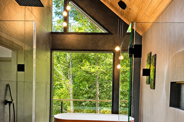 Custom sauna: wood benches, log-slice ceiling and a picture window on the woods. Warm up after a swim.