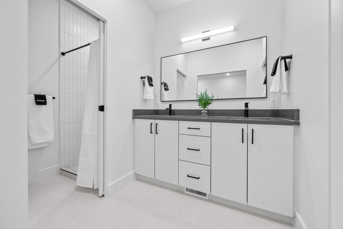Upstairs ensuite bathroom with double vanity and walk-in shower.