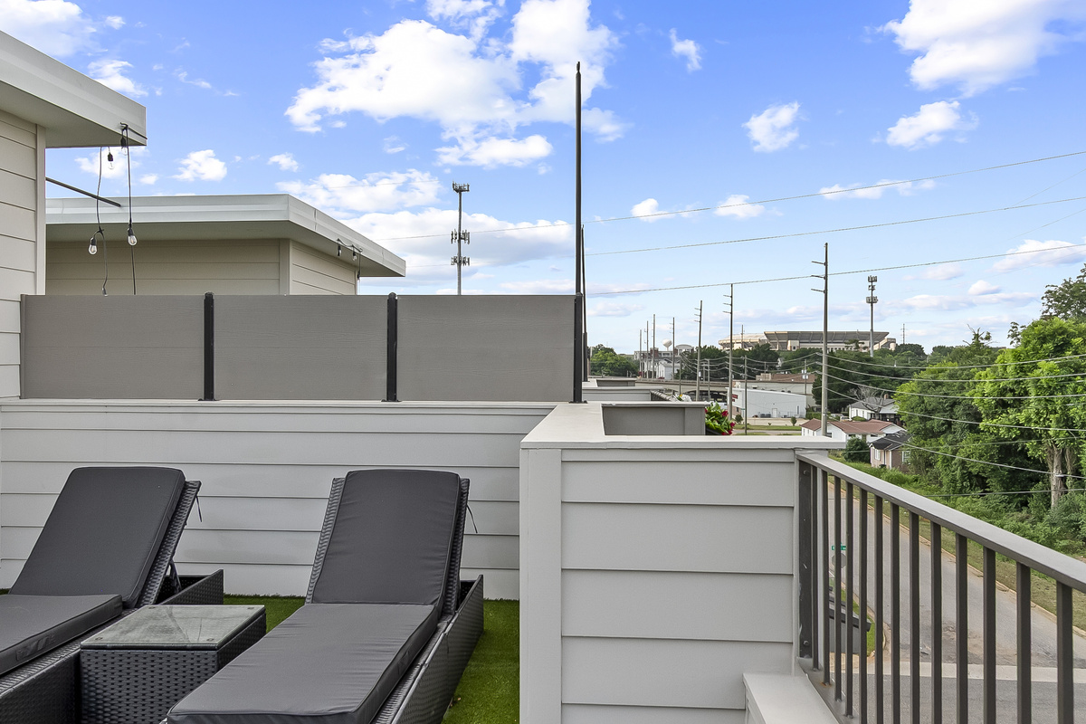 Rooftop Patio with seating, Large TV, gas grill and cornhole.