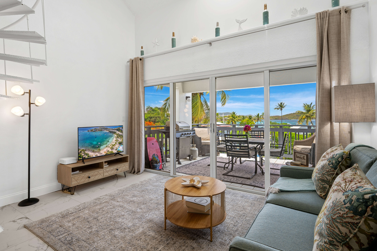 Large windows and deck access fill the living room with natural light.