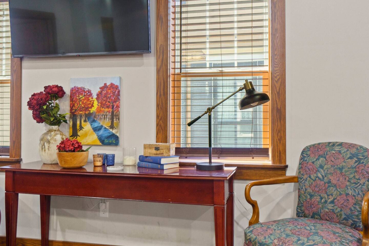 TV setup with a stylish table, lamp, and comfortable seating, creating a cozy and functional entertainment space.
