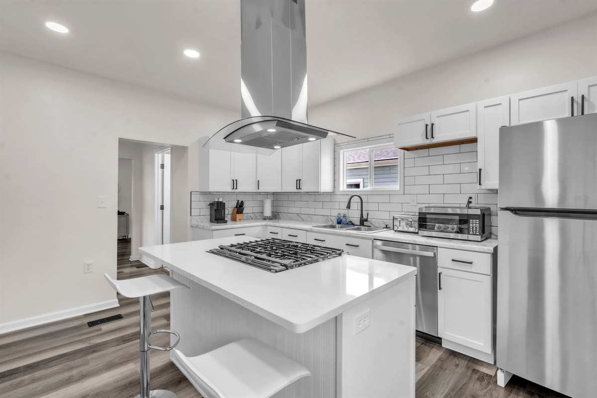 The kitchen features a stylish center island with a built-in burner, blending elegance with functionality for an enjoyable cooking experience.