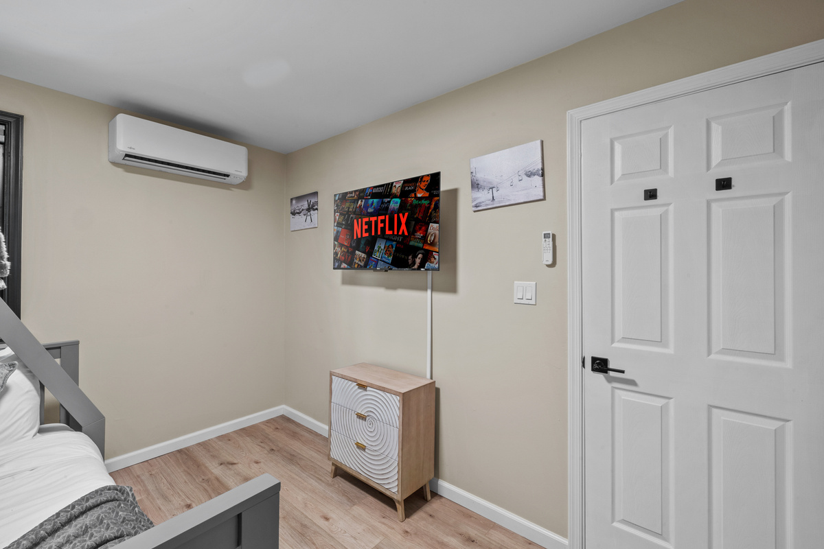 Main floor bunk over full beds with flat-screen TV hangs on the wall for personal entertainment.