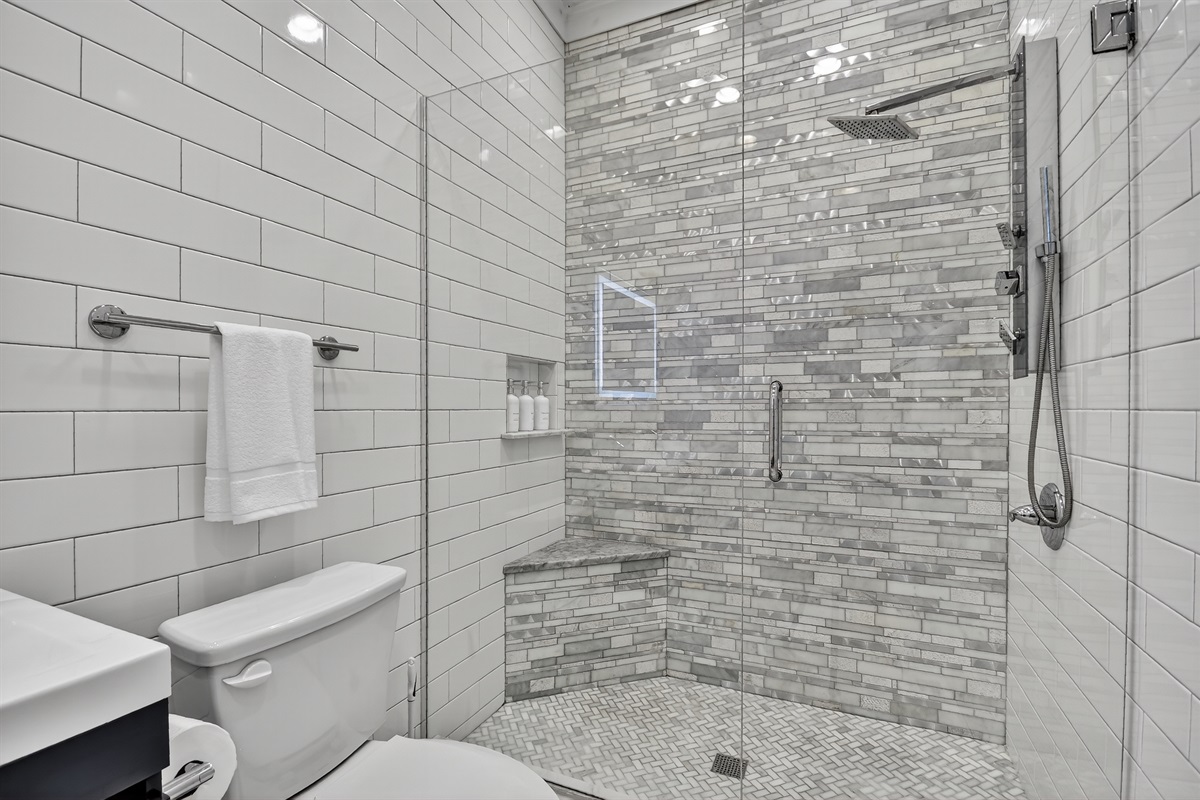 Refresh and recharge in this spa-inspired walk-in shower with marble tile, built-in bench, and rainfall showerhead&mdash;an elevated touch for your cozy Blue Ridge getaway. 