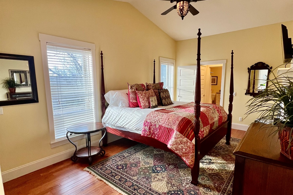 King-size bed with vibrant textiles and artistic accents.