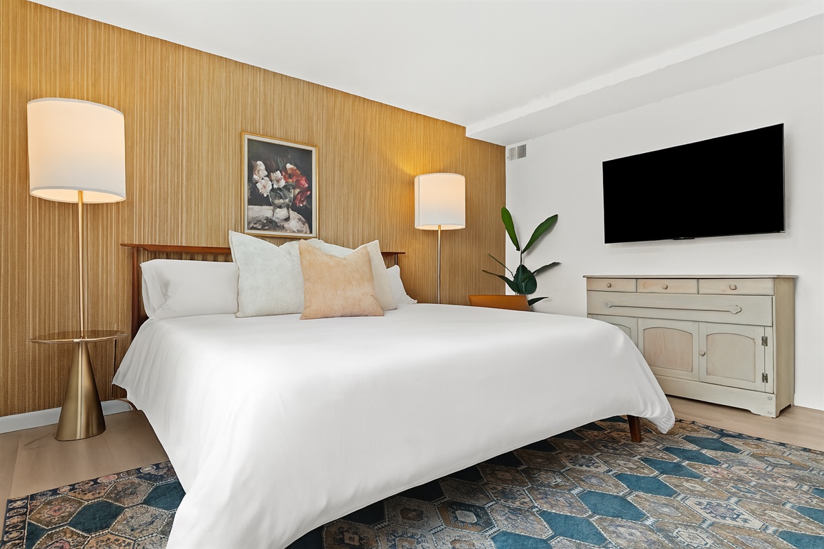 Unwind in this second king bedroom, complete with mounted TV, vintage dresser, and ample closet space.