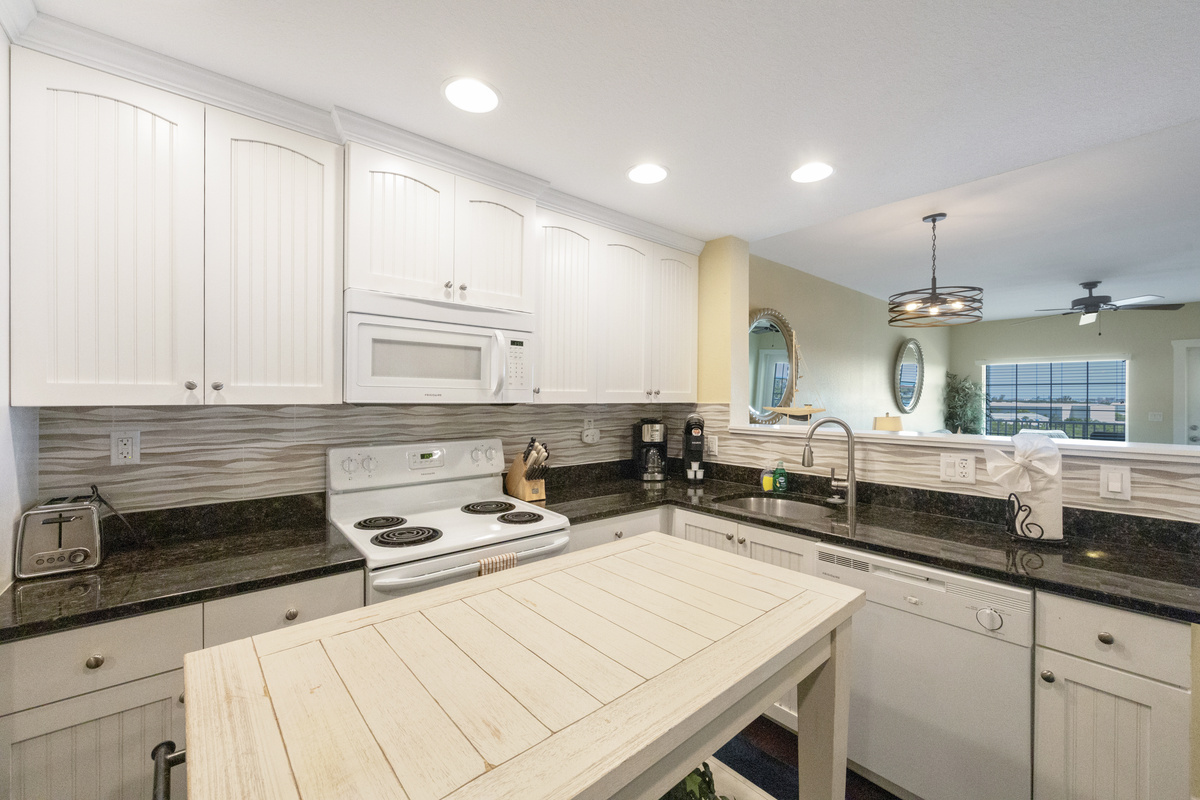Kitchen - fully equipped w/ a microwave, dishwasher, full size fridge, Mr. Coffee, range, stackable washer/dryer, pots/pans, dishes and silverware.