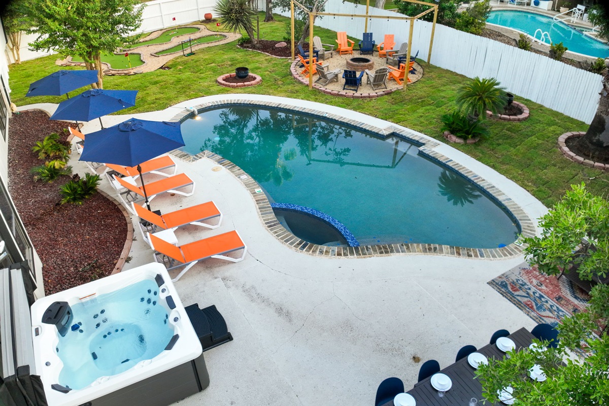 Unwind in the bubbling hot tub while enjoying views of the pool, mini golf, and firepit. The expansive patio offers outdoor dining for 10 and poolside loungers, the perfect backdrop for your San Antonio escape.