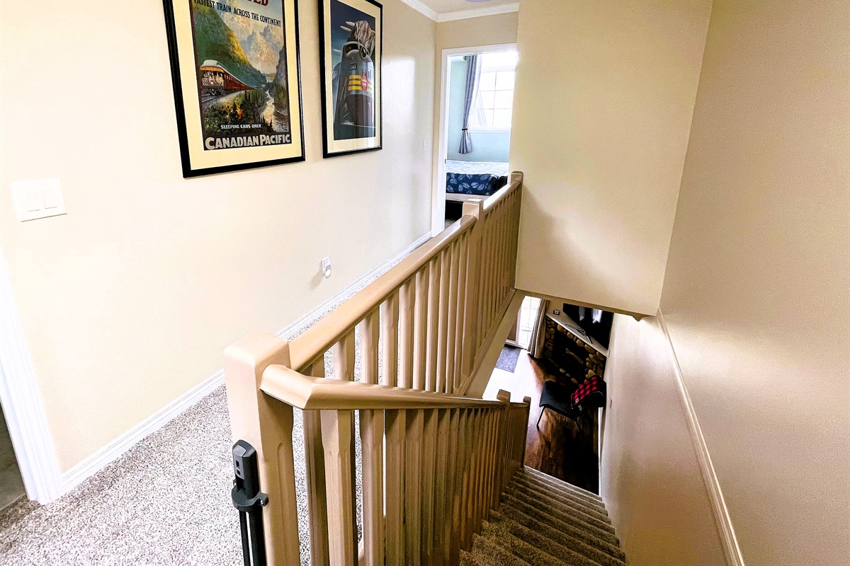 2 bedrooms, and 2 bathrooms on upper floor. Long hallway separates out the the two bedrooms. You can see the guest bedroom on the far side, and entrance to the guest bathroom on the right. There is a stairway, with an optional child gate at the top.
