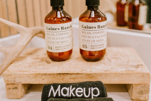 Curated bath amenities at Rancher's Rest &mdash; Gaines Ranch-branded body lotion and hand wash, plus a dedicated makeup cloth so your towels stay pristine.