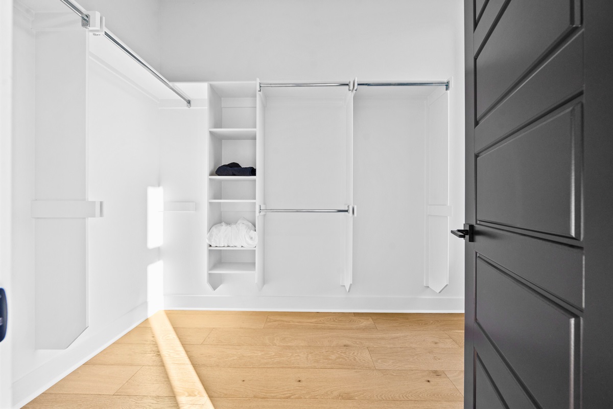 This spacious walk-in closet offers an organized and practical solution, complete with ample hanging space and shelving for all your essentials.